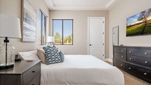 A bedroom with a bed, a dresser, a nightstand, a window, and a painting on the wall. - Dreamy Desert Oasis with Game Room, Heated* Pool! (Scottsdale)