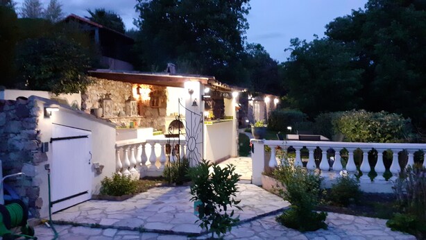 Un bâtiment aux murs de pierre, doté d’un balcon, d’un éclairage extérieur et d’un espace jardin.