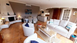 Un salon moderne avec un canapé blanc, une table basse et une cheminée.