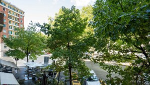 Une vue de rue avec une voiture garée, un passage pour piétons et un immeuble à plusieurs étages.