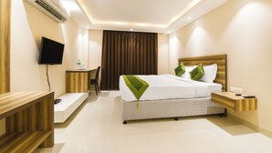 A modern hotel room with a bed, bedside tables, a desk, and a television. - Treebo Iffco Chowk (Gurugram)