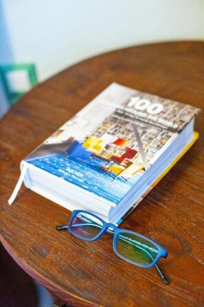 Ein Buch mit dem Titel '100' und einer Brille auf einem Holztisch.