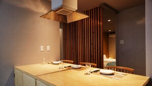 A dining area with a wooden table, chairs, and a built-in stove. - ADAN RESORT Lamp (Motobu)