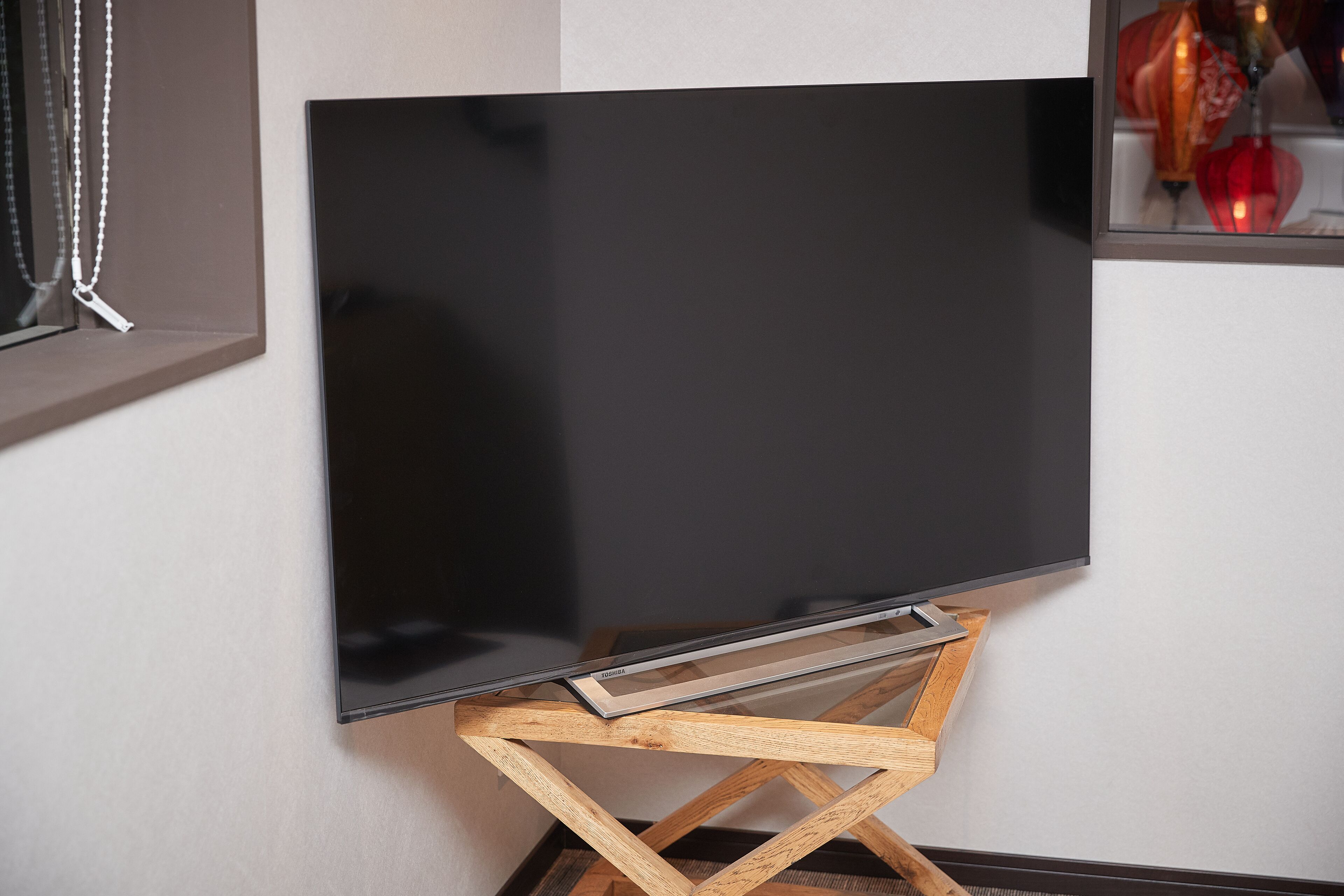 Ein Flachbildfernseher auf einem Holzboden an einer Wand.