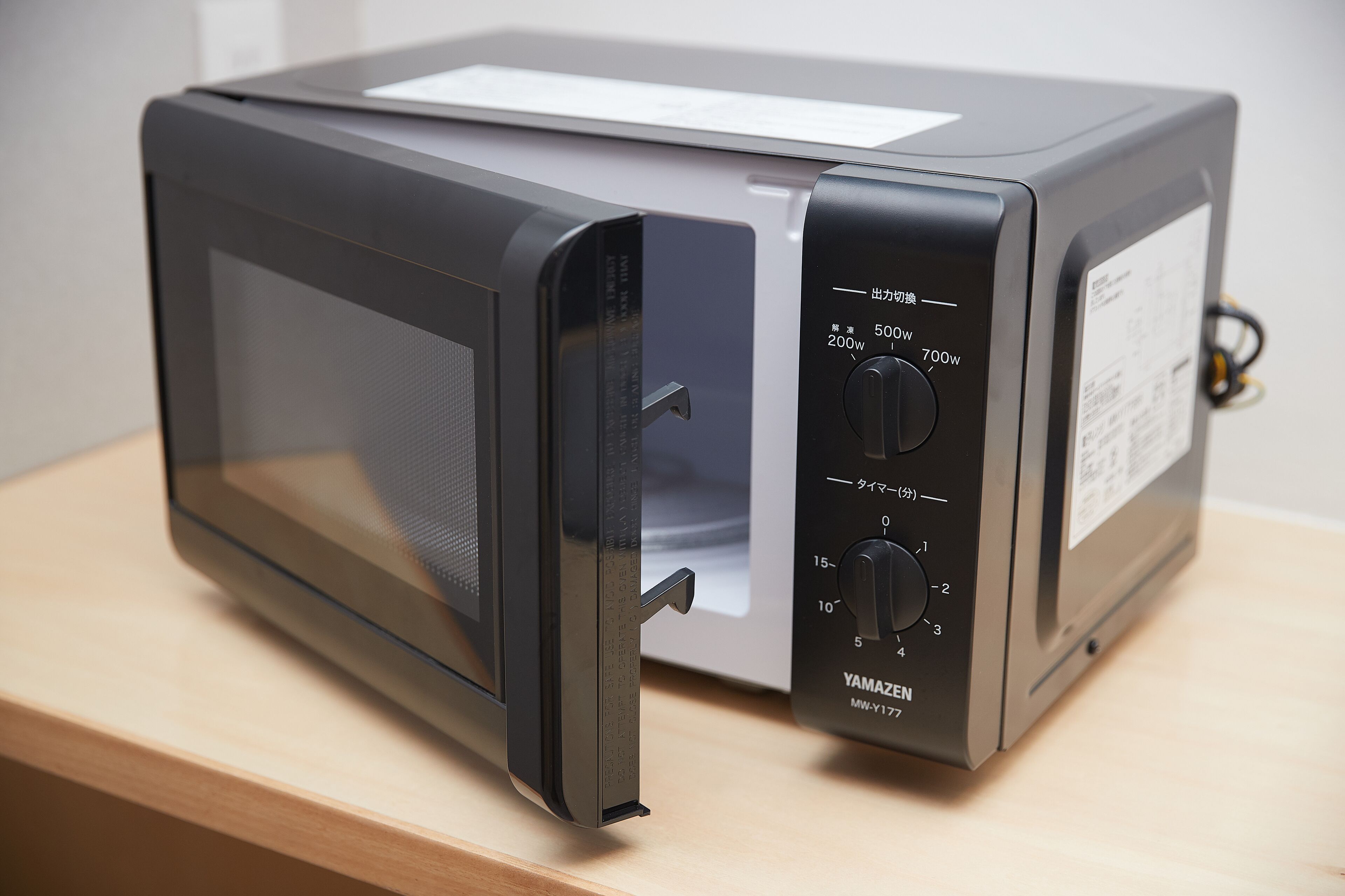 Un horno microondas con pantalla digital y perillas de control.