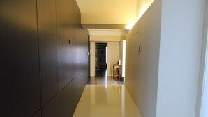 A hallway with dark wooden paneling on one side and a white wall on the other, leading to a room with a door at the end. - Chicca suite with terrace in the heart of the historic center of Catania (catania)