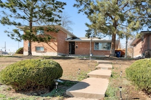 Stunning brick home with a modern design, featuring a cozy front porch and beautifully manicured lawn.