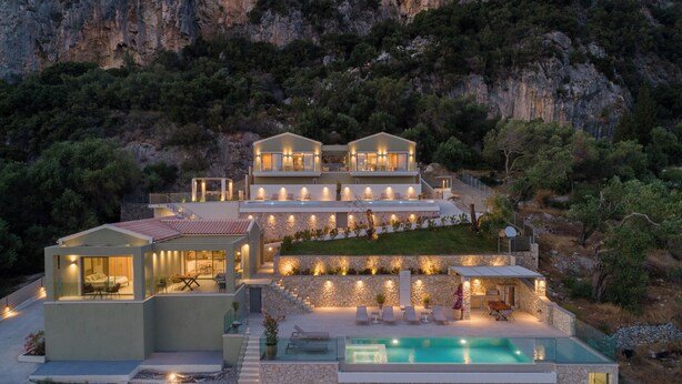 A modern villa with a swimming pool, multiple levels, and outdoor lighting.