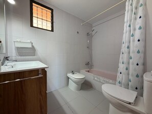 Ein Badezimmer mit Waschbecken, Toilette, Bidet und Badewanne.