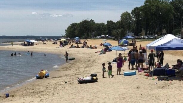 Une plage avec des gens, des tentes et du matériel de plage.