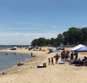 A beach with people, tents, and beach equipment.