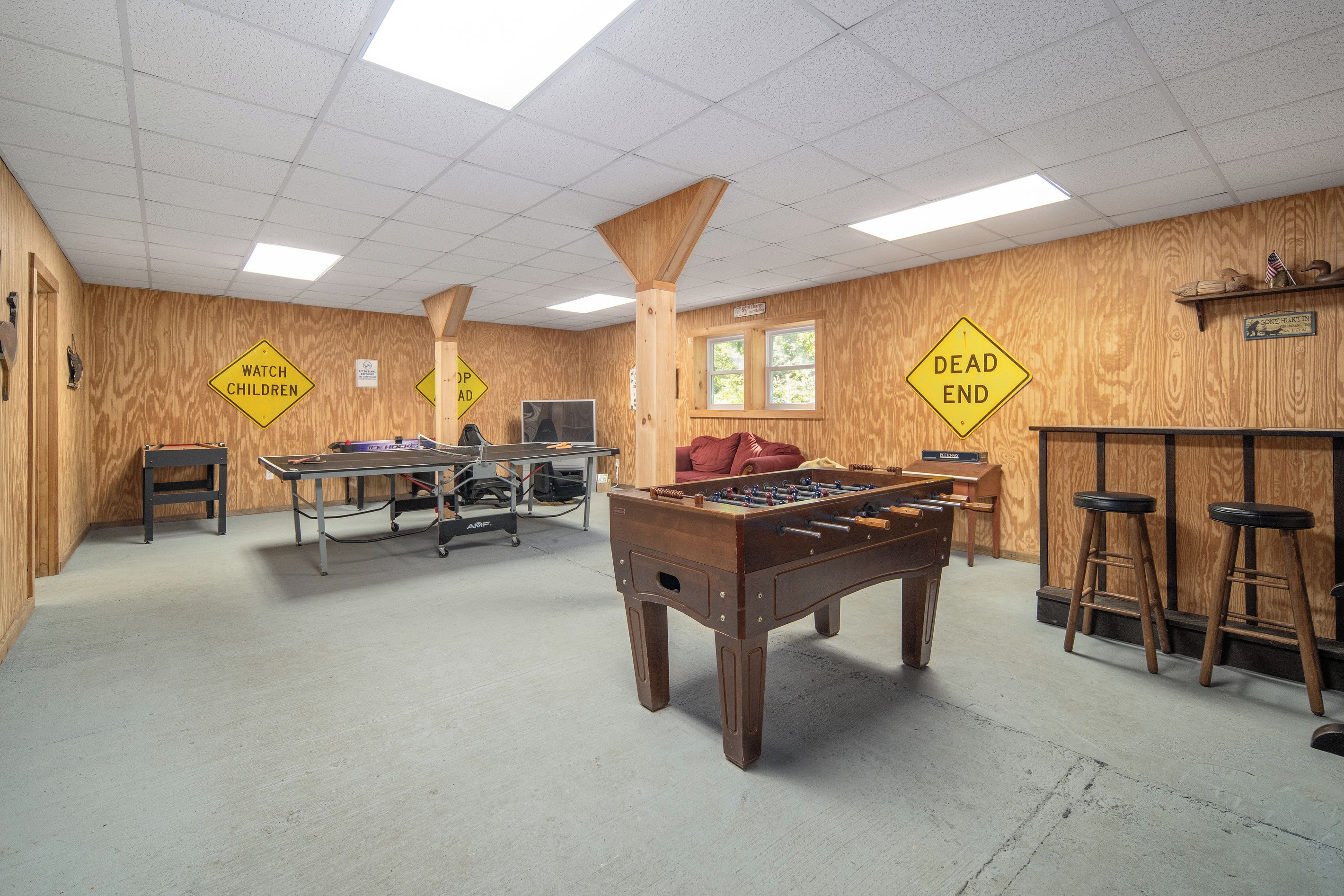 Una sala de recreación con mesa de futbolín, mesa de ping pong y mesa de billar.