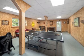 Una mesa de ping pong en una habitación con paredes de madera, un letrero que dice 'DEAD END' y varias decoraciones en la pared.