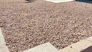 A modern building with a garage, gravel driveway, and a small parking area. - "BRAND NEW" 2 bedroom, 1 bath duplex/home  (Yuma)