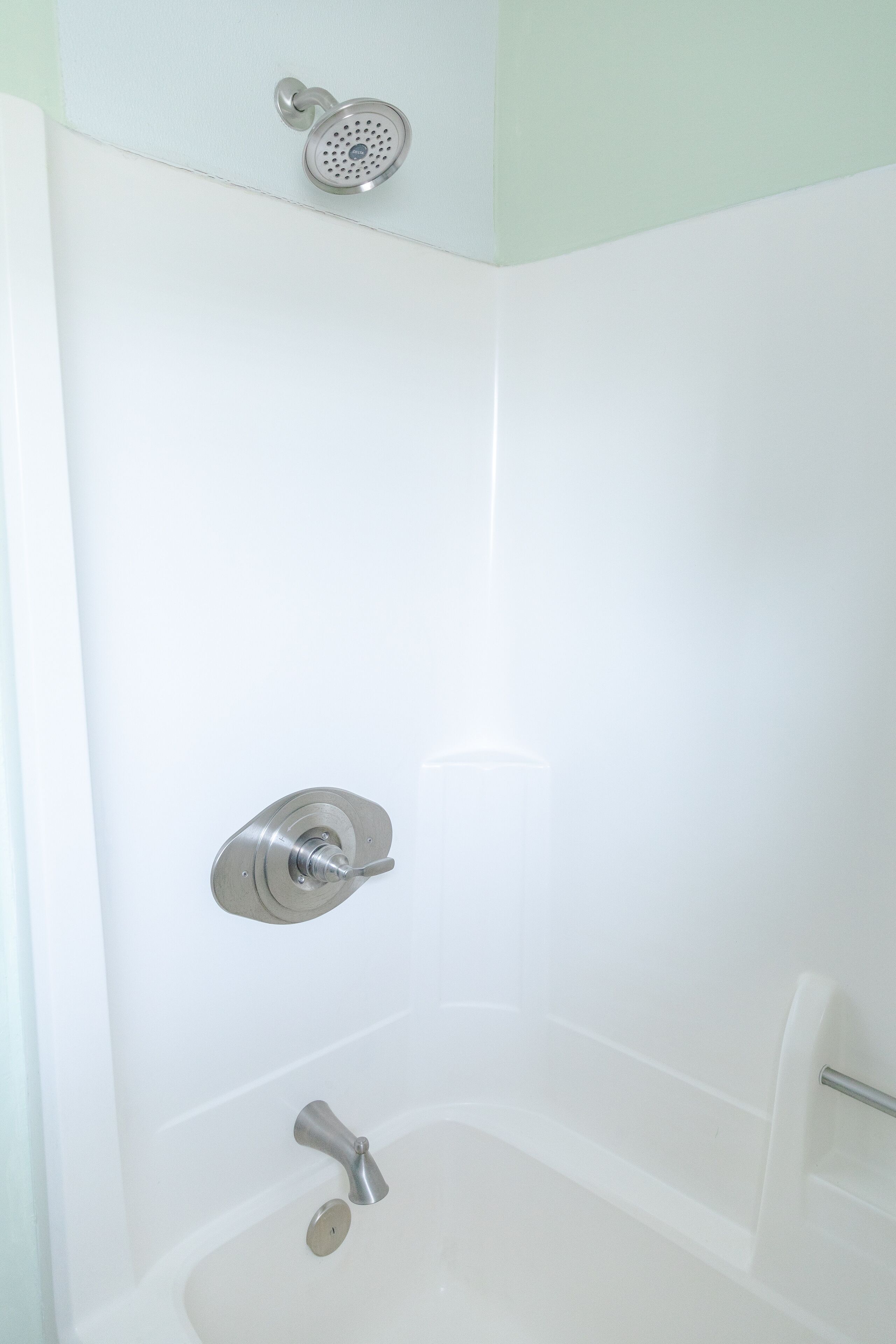 A corner of a bathroom with a shower, a bathtub, and a toilet.