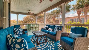 A covered outdoor seating area with blue furniture and patterned cushions. - Come and Wind Down and Relax at Family Tides! (Georgetown)