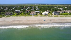 An aerial view of a coastal residential area with houses, a sandy beach, and ocean waves. - Come and Wind Down and Relax at Family Tides! (Georgetown)