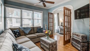 A living room with a sectional sofa, a coffee table, and a television. - Come and Wind Down and Relax at Family Tides! (Georgetown)