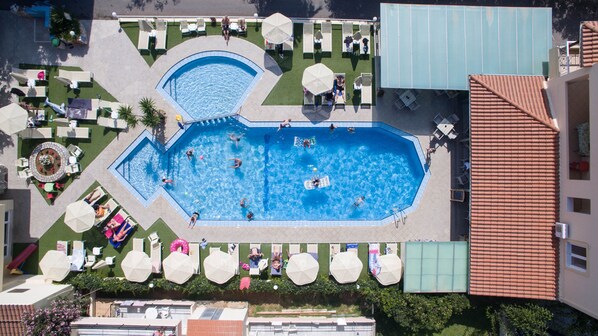 Relax by the rectangular pool surrounded by lounge chairs and umbrellas, with a beautiful view of the landscaped rooftop.