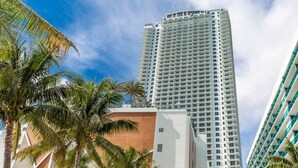 A tall, modern hotel with a curved facade, surrounded by palm trees and under a clear sky. - Hyde Beach House Luxury -resort 3 Bedroom Condo by RedAwning (Hollywood)