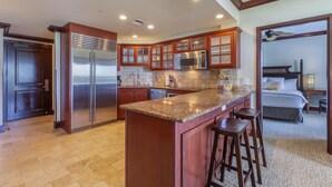 Una cocina moderna con encimeras de granito, electrodomésticos de acero inoxidable y armarios de madera.