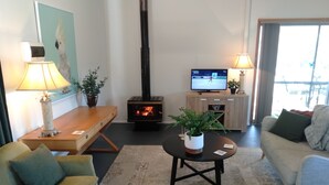 A cozy living room with a fireplace, a television, and comfortable seating. - Moonlight Studio- Nannup's favourite accommodation.  (Nannup)