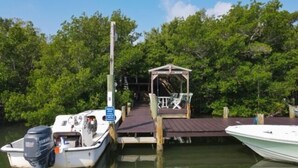 A dock with a small wooden structure and a boat moored alongside. - Welcome to DOCKTAILS - direct Bayfront - tropical private island - PRIVATE DOCK (Placida)