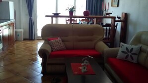 Un salon comprenant un canapé, une table basse et un coin repas avec une table et des chaises.