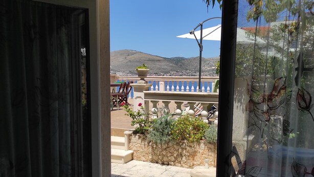 Une porte donnant sur un balcon d’où l’on peut admirer un paysage montagneux.