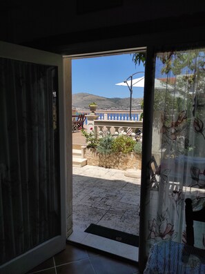 Une porte donnant sur un balcon d’où l’on peut admirer un paysage montagneux.