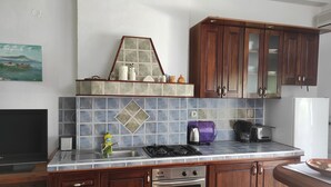 Une cuisine avec des meubles de rangement en bois, un pare-feu en carreaux, une cuisinière, un grille-pain et un réfrigérateur.