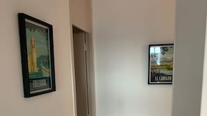 A hallway with a framed picture of a lighthouse and a sign reading "LE CANIGOU".