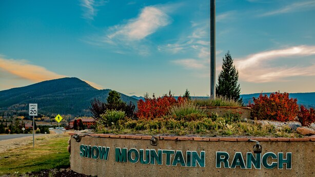 A sign for Snow Mountain Ranch with a speed limit sign and a pedestrian crossing sign in the background. - YMCA of the Rockies Snow Mountain Ranch (Granby)