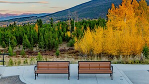 Two wooden benches facing a mountainous landscape with autumn foliage. - YMCA of the Rockies Snow Mountain Ranch (Granby)