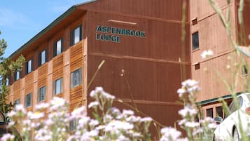 Un edificio de madera con el letrero "Aspenbrook Lodge" en su fachada.