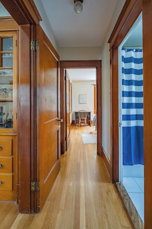 Stunning hallway leads to a dining area with a wooden table and chairs.