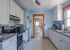 Kitchen features a double sink, oven, and stainless steel range hood.