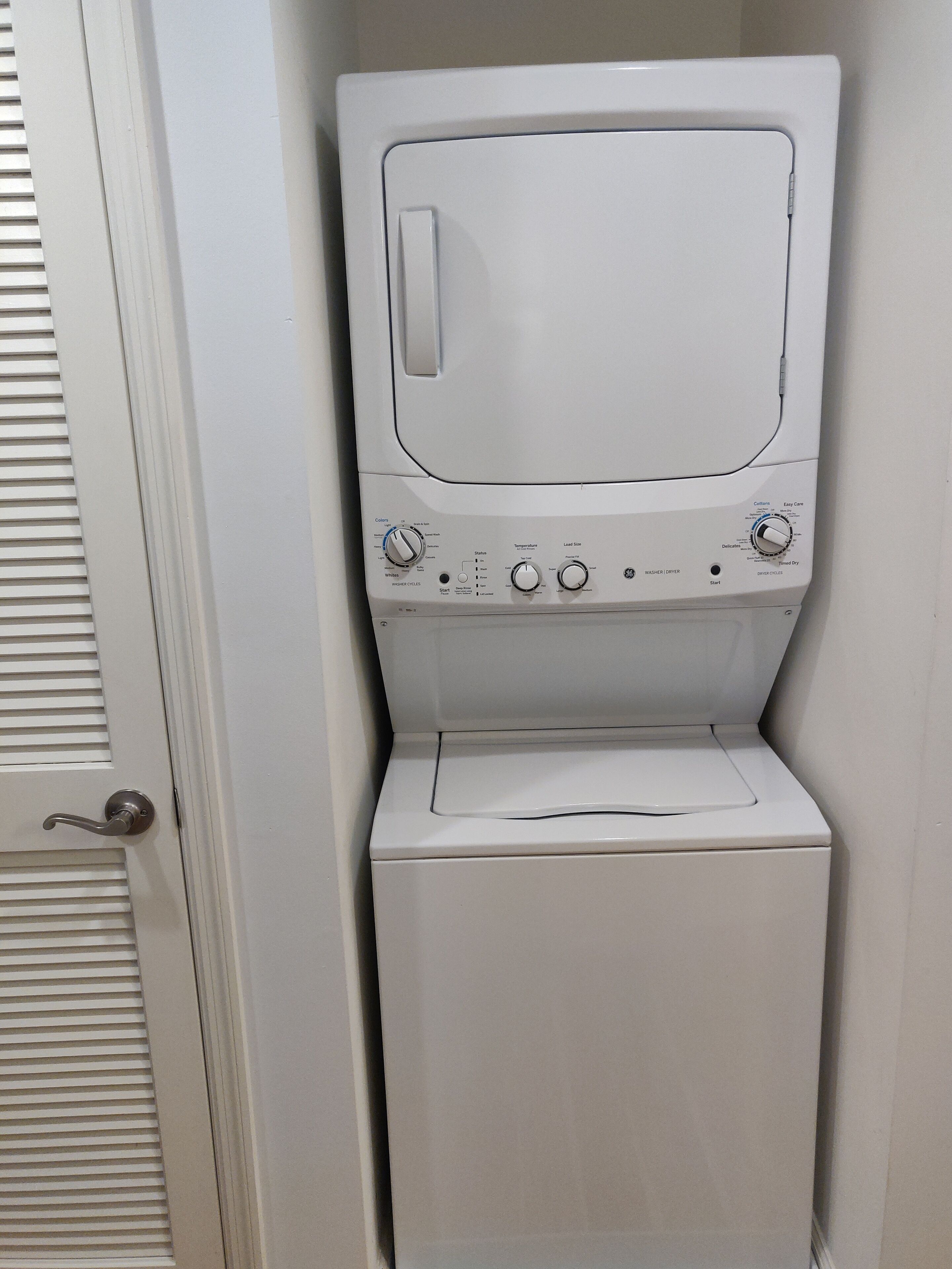 A white washing machine with control knobs and a door handle.