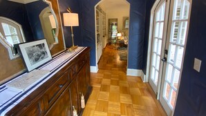 A hallway with a wooden floor, a mirror, a lamp, and a door leading to another room. - Luxury Villa near Siesta - private, heated screened pool (Sarasota)