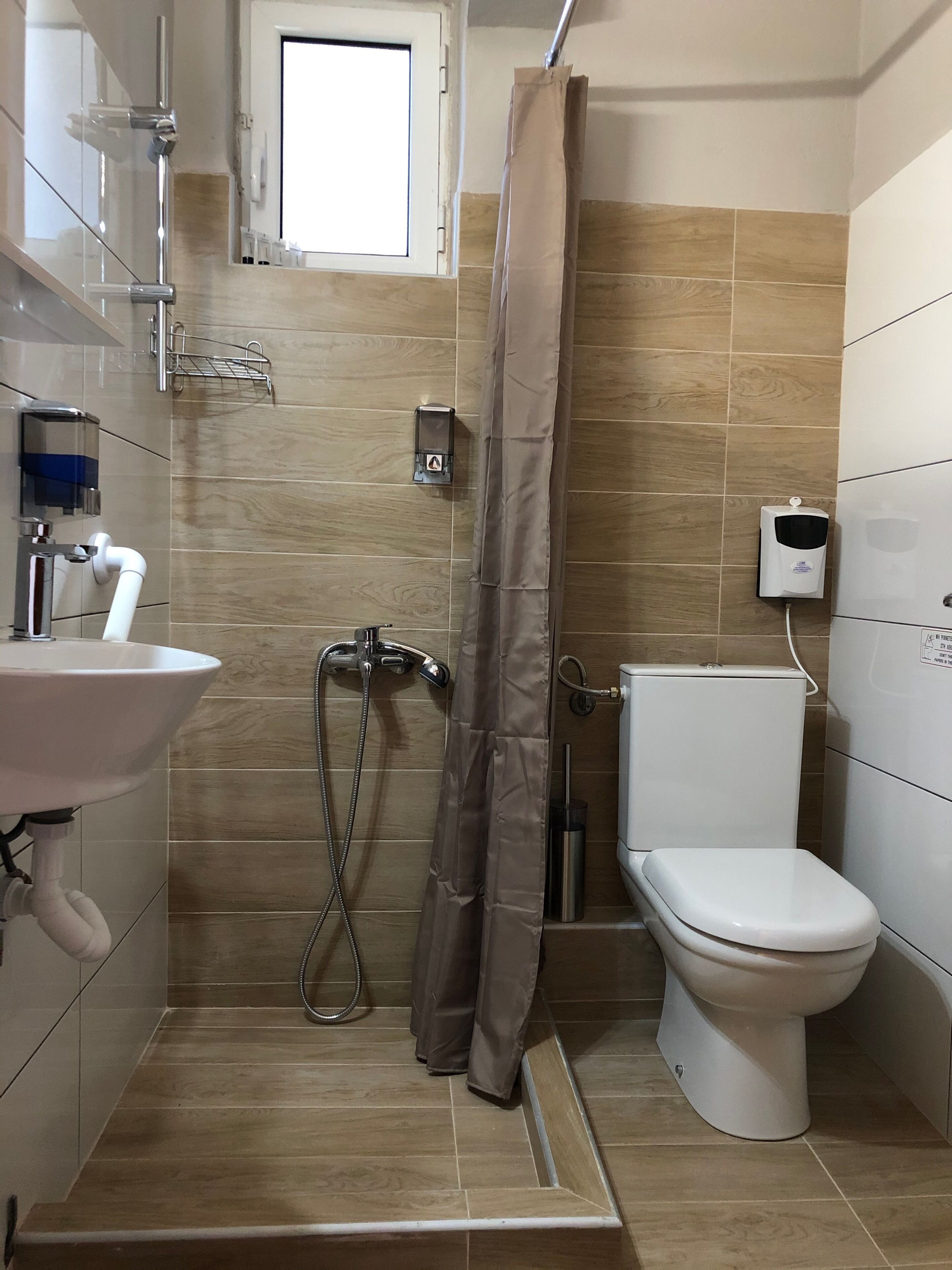 A bathroom with a shower, toilet, and sink.