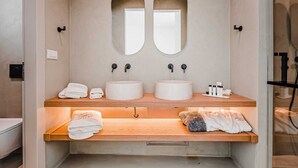A bathroom with two sinks, two mirrors, and a towel rack. - One Bedroom Suite, Amarelo Suites (Mykonos)