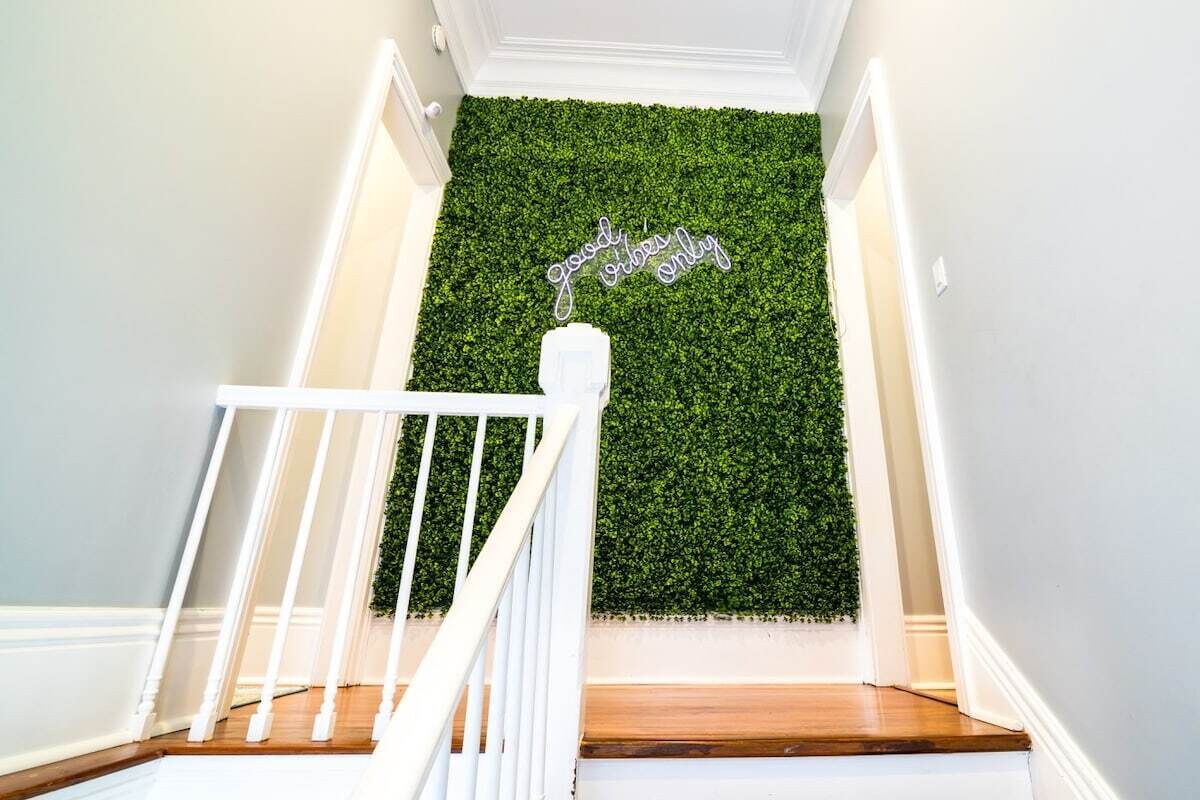 A staircase with a green wall and a sign that reads 'good vibes only.'
