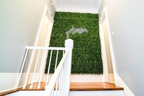 Un escalier avec un mur vert et une pancarte sur laquelle on peut lire : « Seules les bonnes ondes sont les bienvenues. »