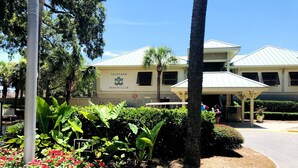 A building labeled 'Shipyard Beach Club' with a covered outdoor seating area and lush landscaping. - HUGE 4 BR/3 BATH Villa 15 minute walk to Beach (3 min walk to the pool) (Hilton Head Island)