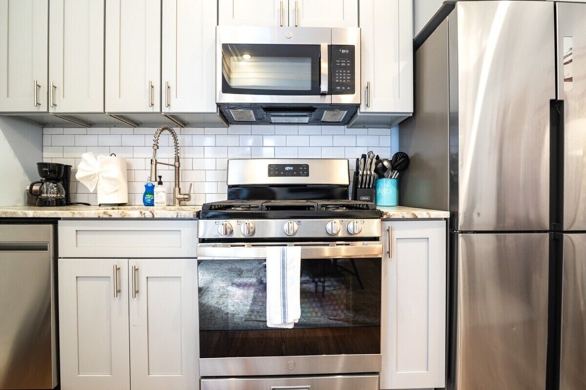 A kitchen with stainless steel appliances, including a microwave, stove, oven, and refrigerator.