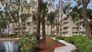 Un espace paysager agrémenté d’un élément aquatique, de sentiers et d’immeubles à plusieurs étages dotés de balcons.