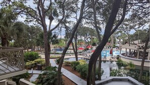 Un complexe hôtelier doté d’une piscine, de chaises longues et d’une terrasse en bois.