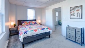 A bedroom with a bed, bedside lamps, a dresser, and a window. - Parkview, Apt #5
Parkview Historic Apartment (Hershey)