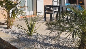 A building with a patio area, outdoor seating, and a barbecue grill.