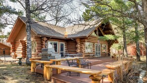 A log cabin with a deck, outdoor seating, and a grill area. - Eagle's Landing- Beach Front Log Home  - RARE FIND on Beautiful Woman Lake! (Longville)
